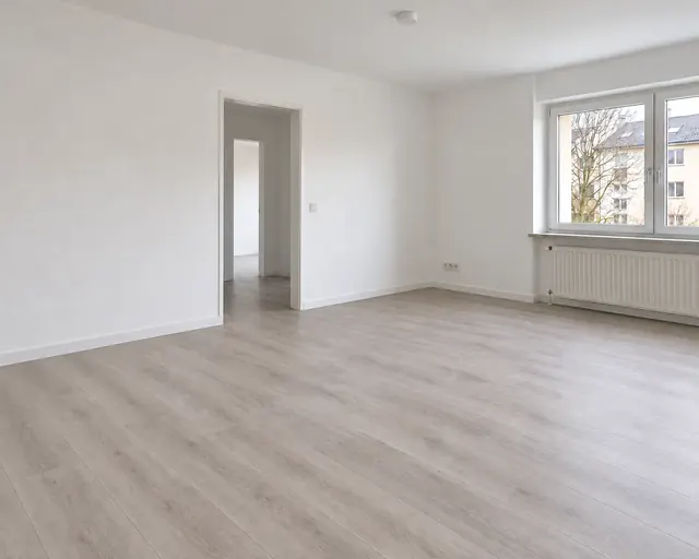 Beispielbild: derselbe Raum renoviert, mit hellem Boden, glatten Wänden und Sockelleisten